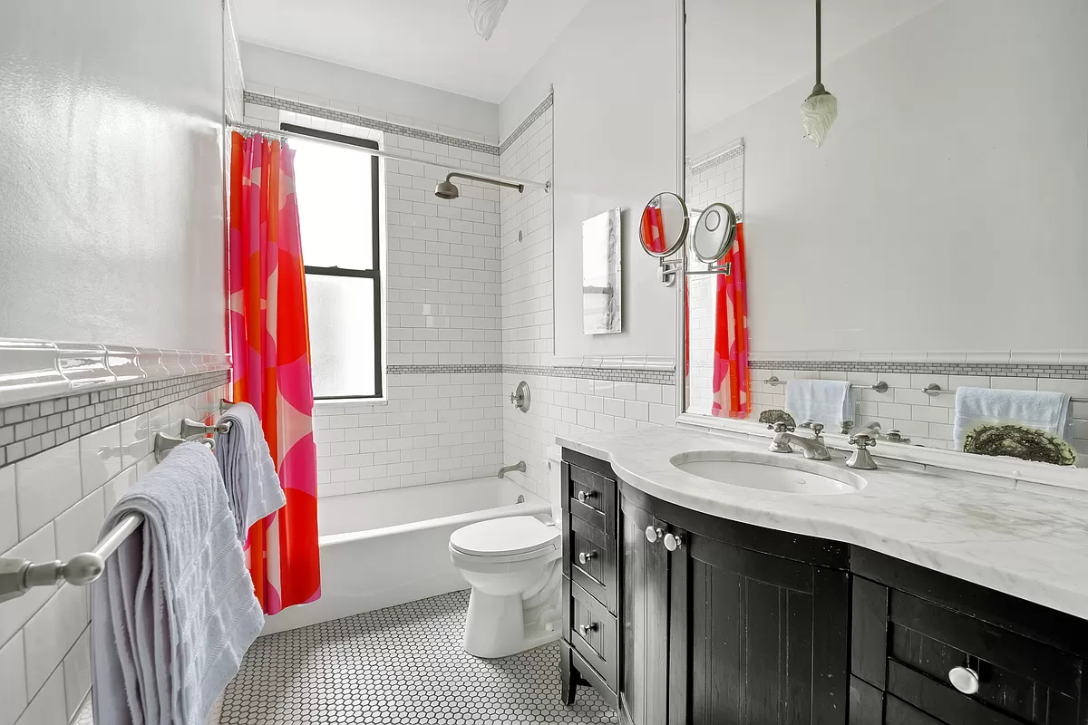 bathroom with black vanity and white subway tile walls