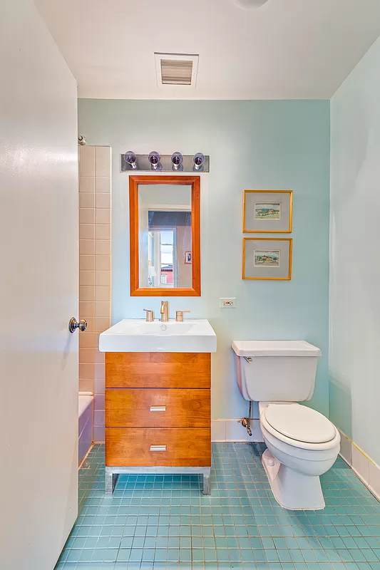 bathroom with blue tile floor and white fixtures