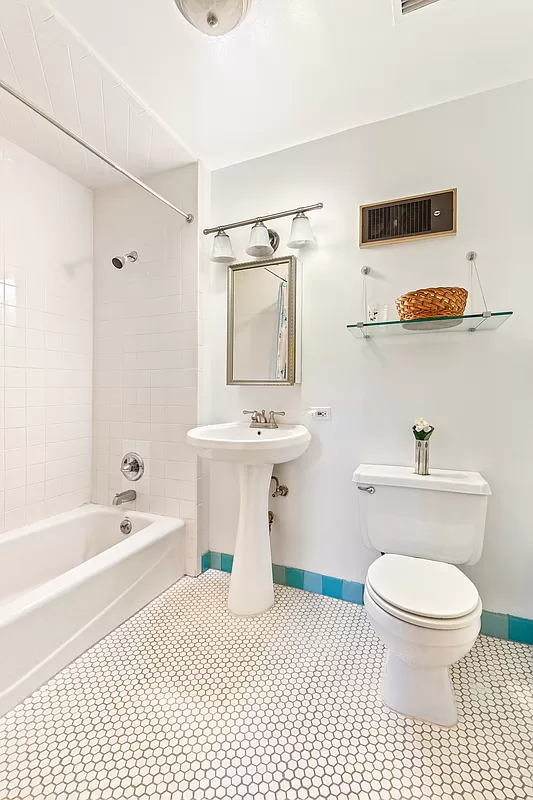 bathroom with white fixtures and a blue border tile