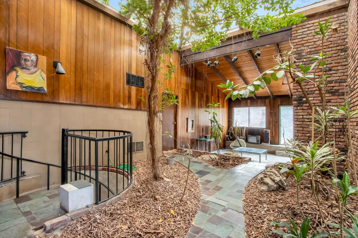 entry with stone path through atrium with tree