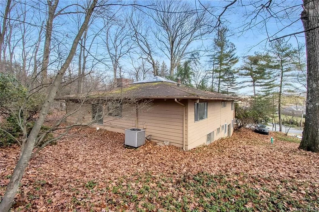 rear facade showing slope of the site with leaves covering the lawn