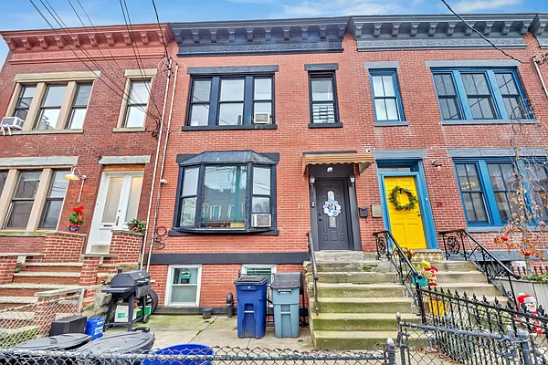 red hook - brick row house with cornice and bay window