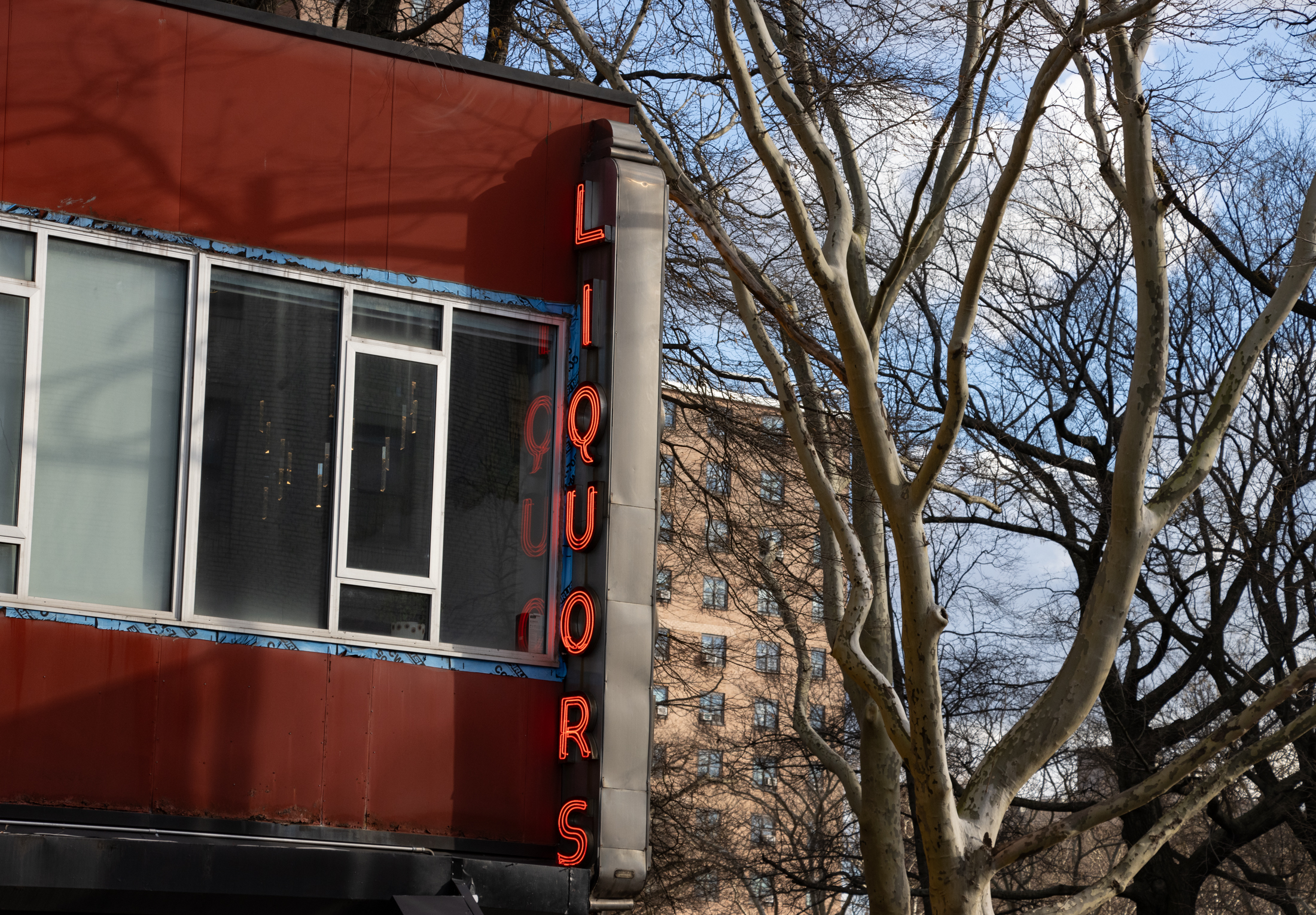 brooklyn- neon liquor sign reflected in window