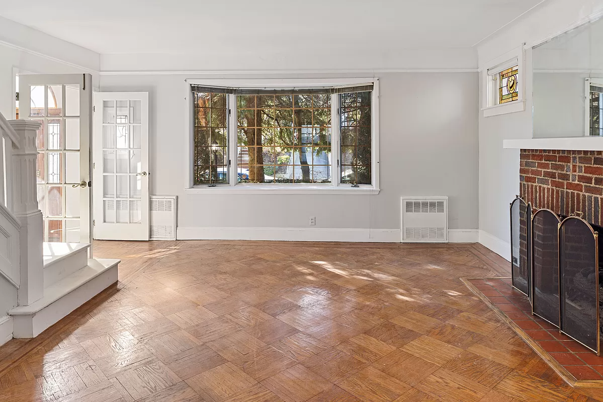 living room with a brick mantel and a small bay window