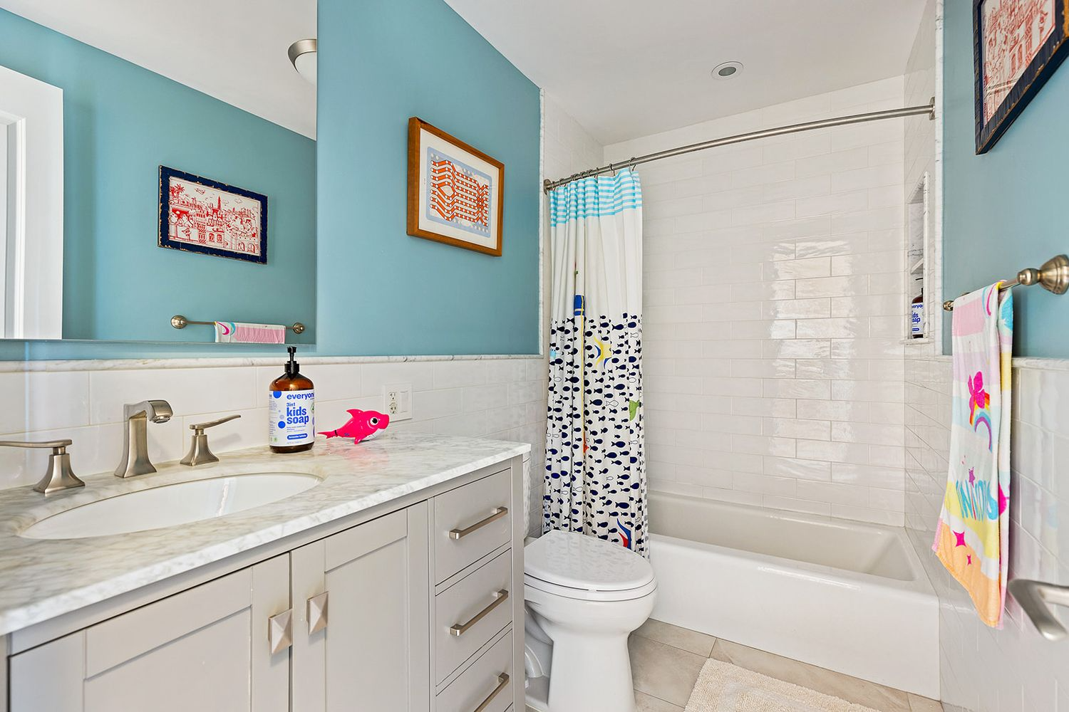 bathroom with gray vanity white subway tile and blue painted walls
