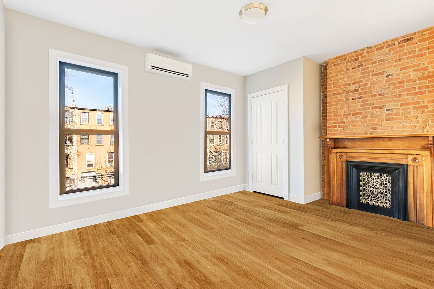 bedroom with exposed brick and a wood mantel