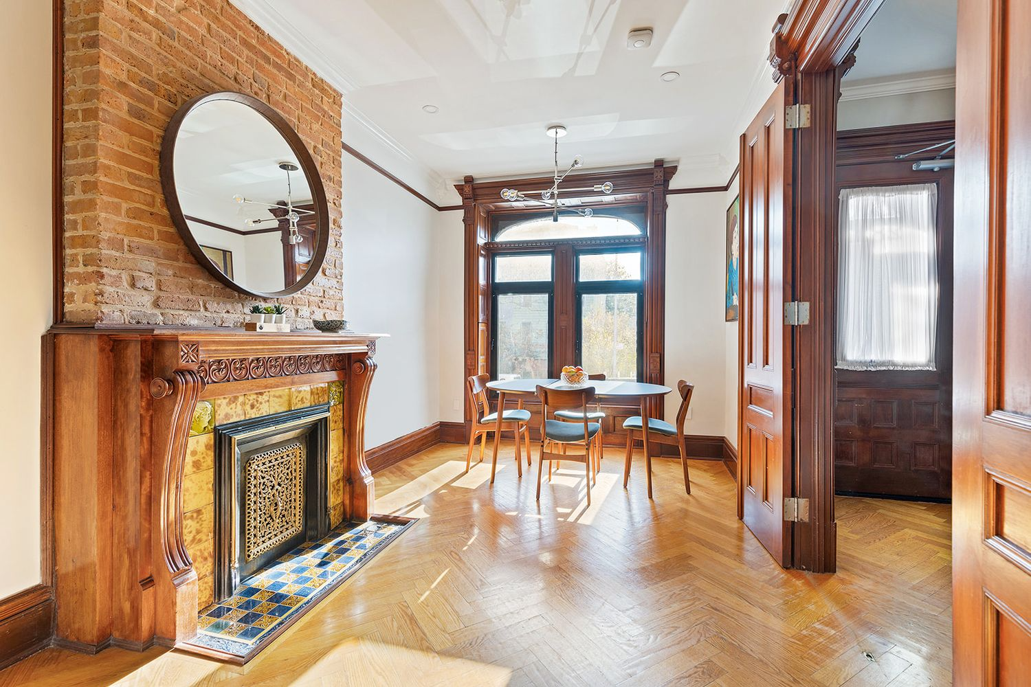 bed stuy - parlor with wood moldings and a mantel with original tile