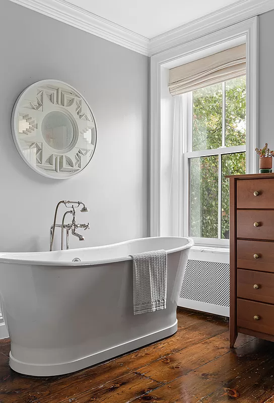 bathroom with wood floor and a soaking tub