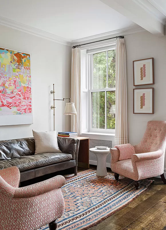 corner of bedroom set up as a sitting area with sofa and wing chairs