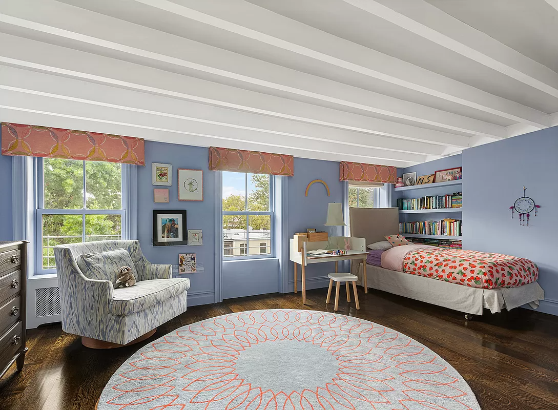 bedroom with three windows and exposed beams painted white