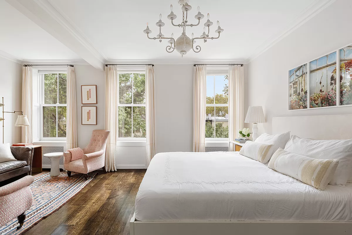 bedroom with three windows and a seating area