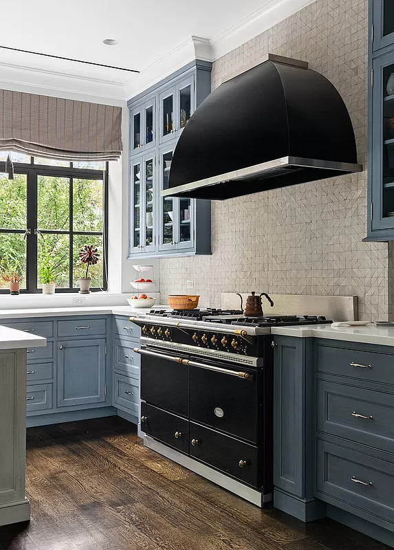 kitchen with blue cabinets and a black stove and hood
