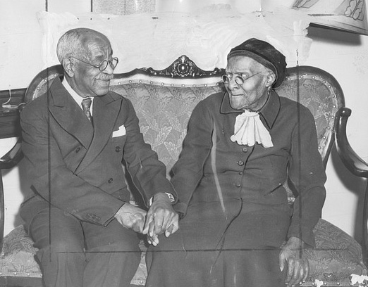 black and white photo of people holding hands on the sofa