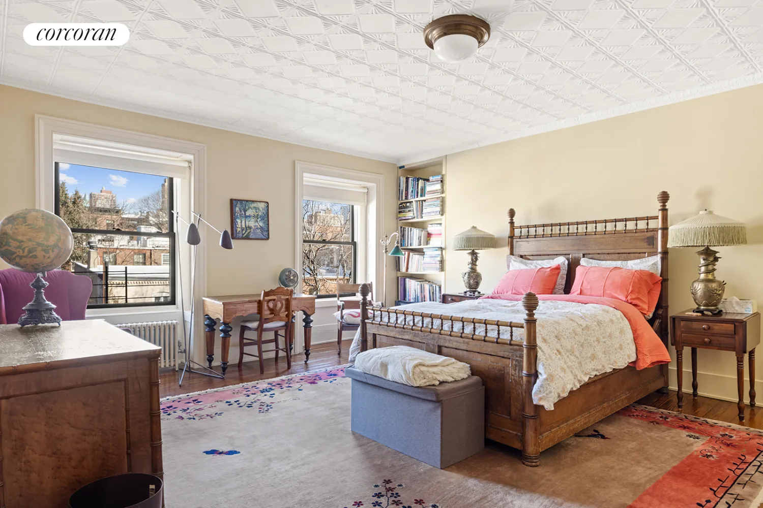 top floor bedroom with tin ceiling and wood floor