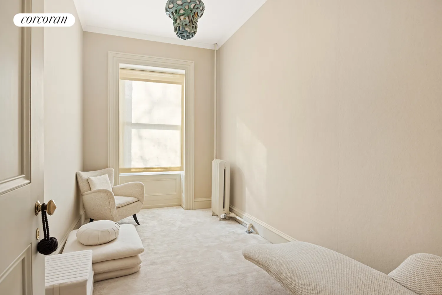 narrow bedroom with beige carpet and walls