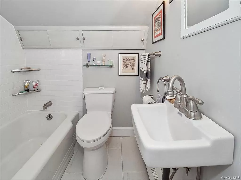 bathroom with white fixtures including a tub without a shower