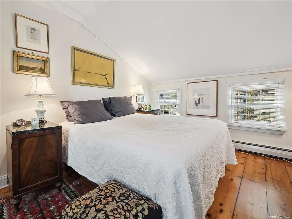 top floor bedroom with wide floor boards and two small windows