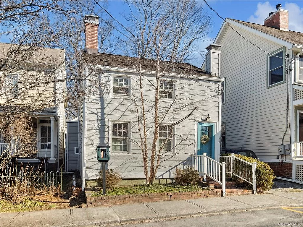 cold spring - petite house with gray siding and a bright blue door