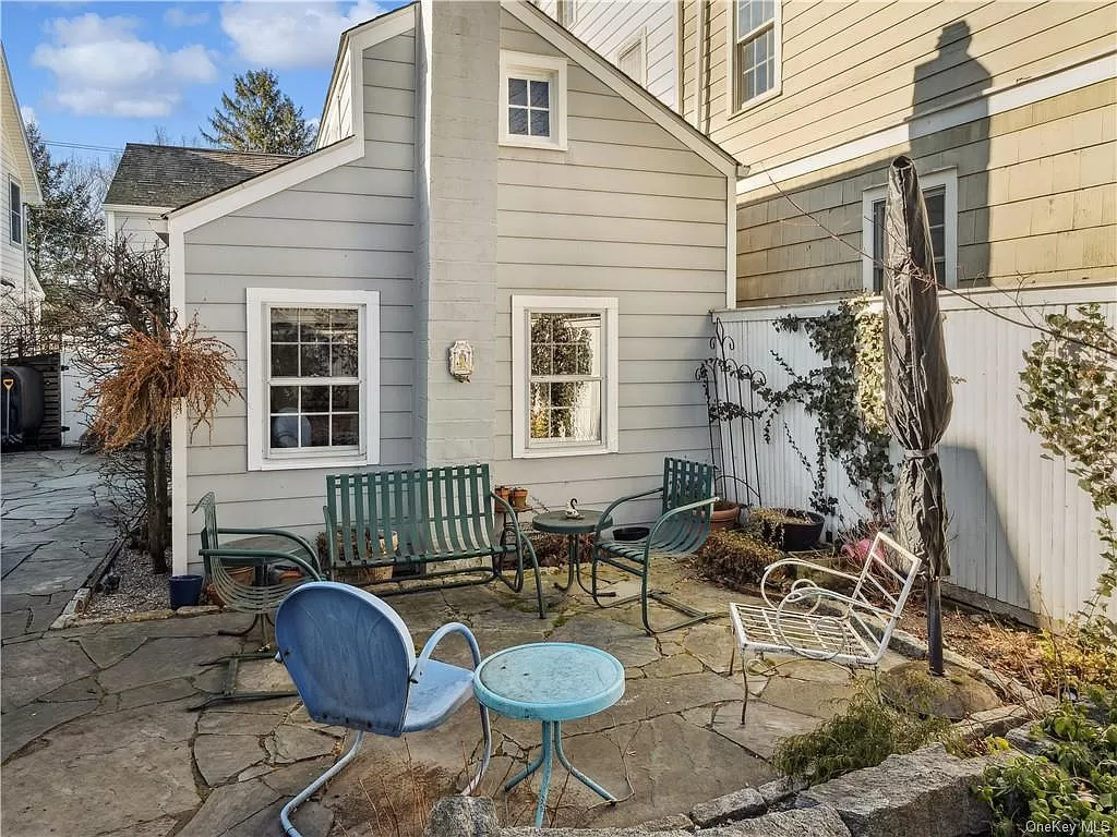 stone patio in the rear yard with planting beds