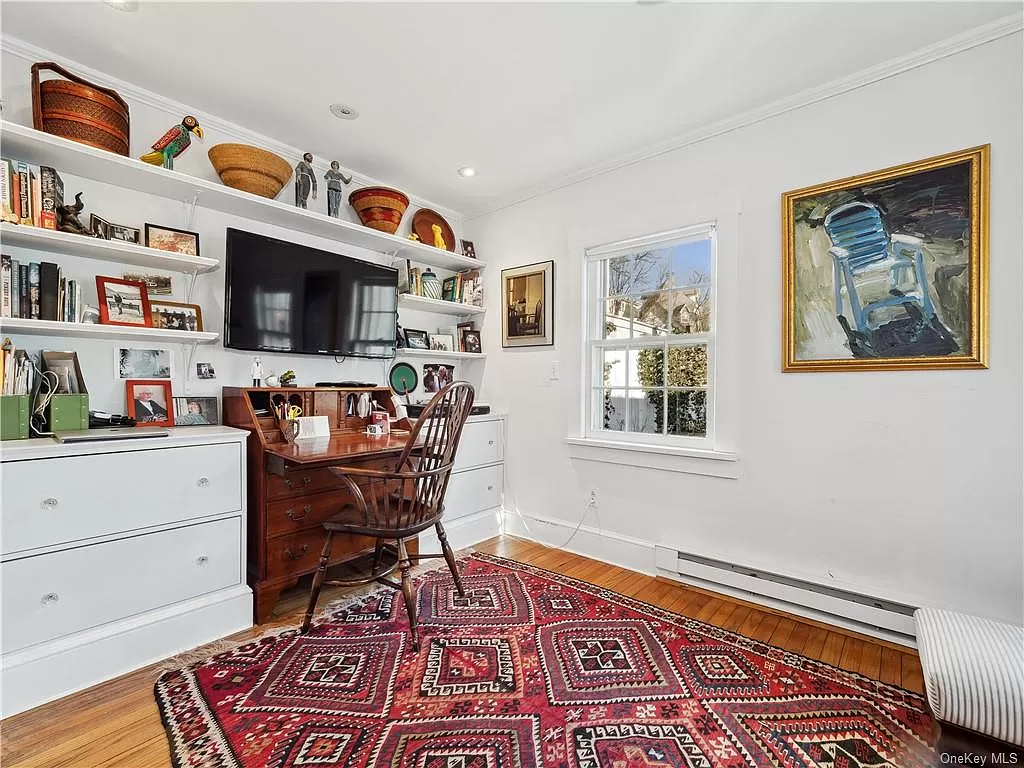 office set up in bedroom with wood floor