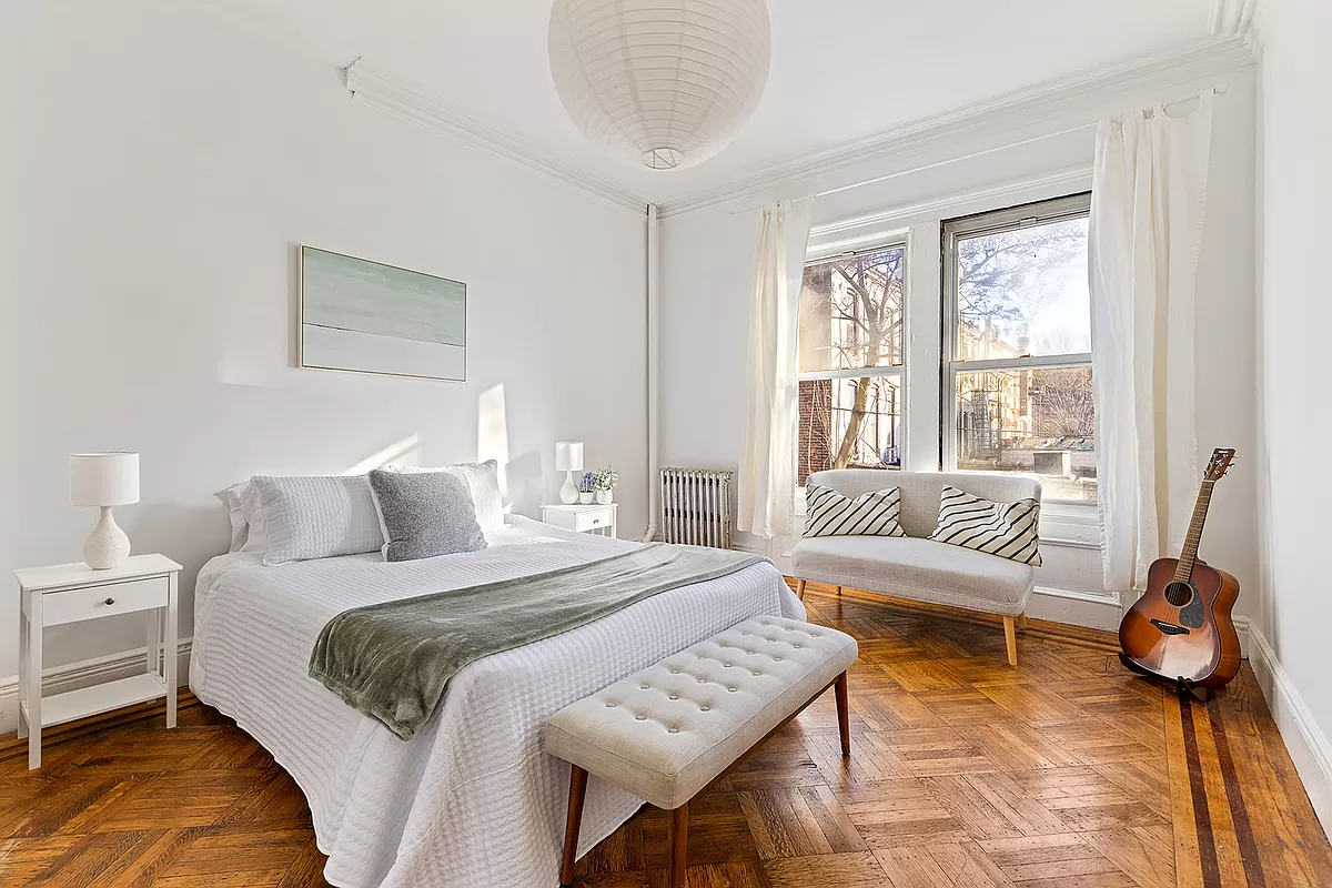 bedroom with wood floor and two windows