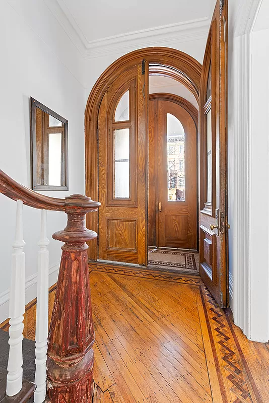 entry with newel post and arched entry