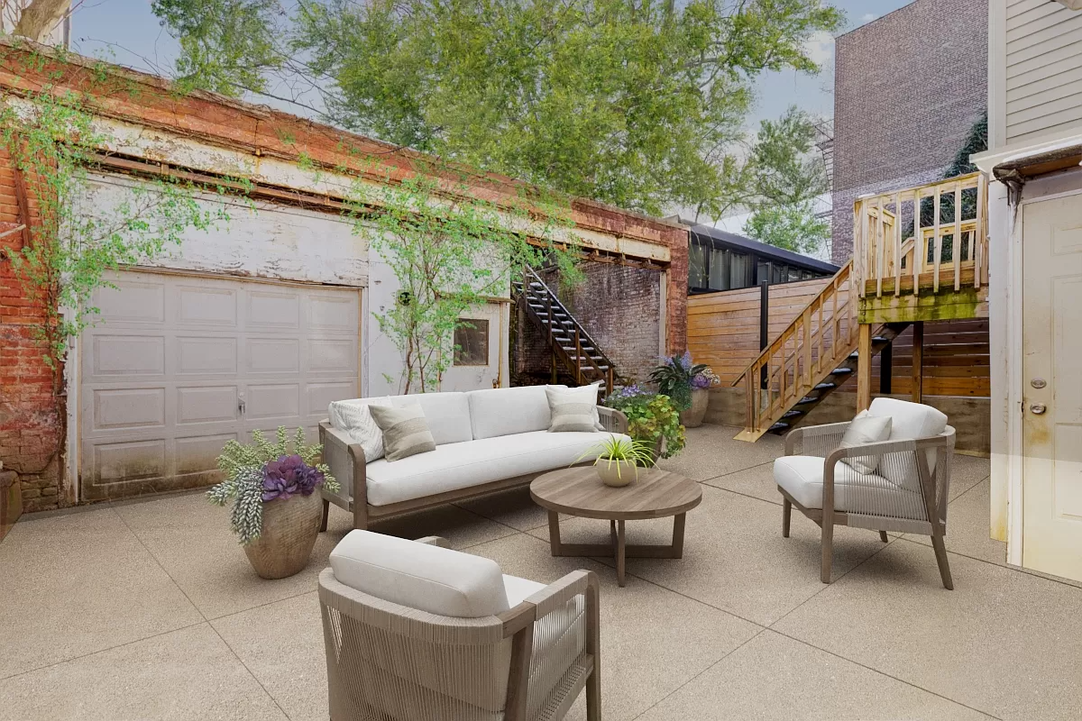 virtually staged rear yard with paved patio and sofas