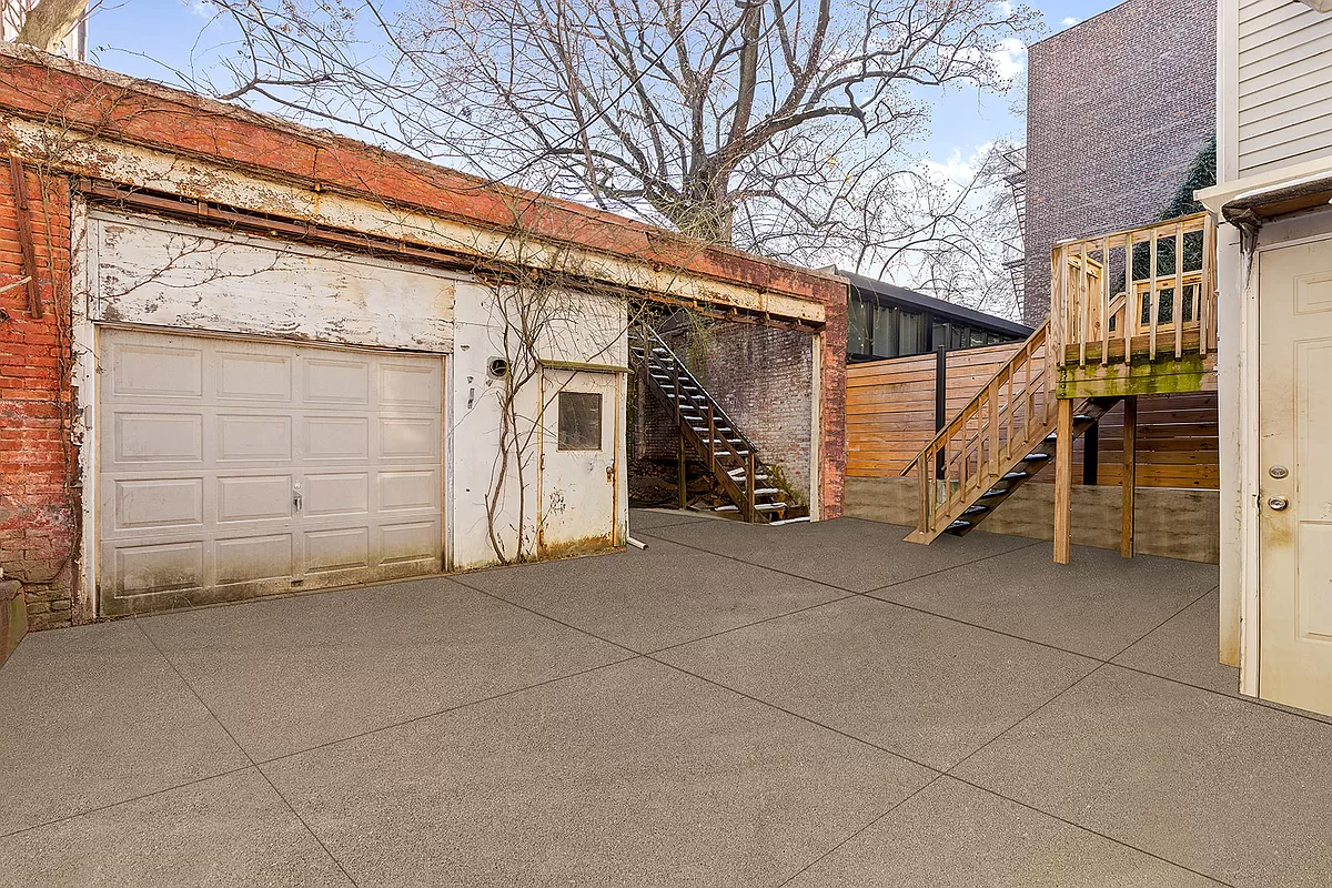 rear yard with pavers and a garage
