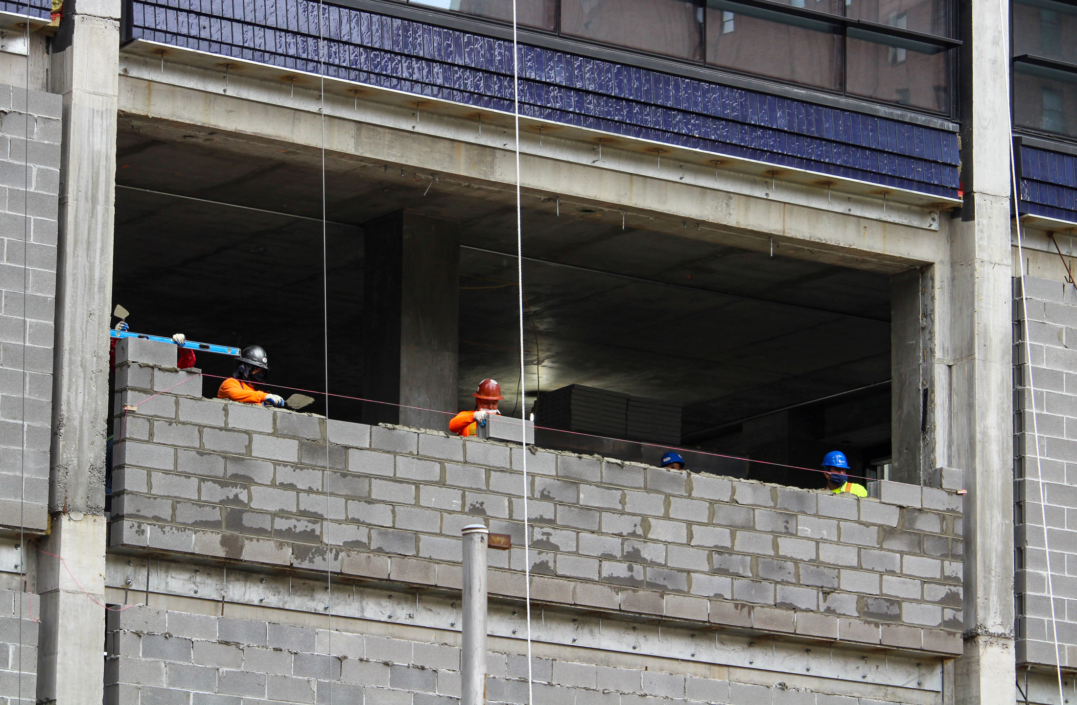 construction workers putting cement blocks in place
