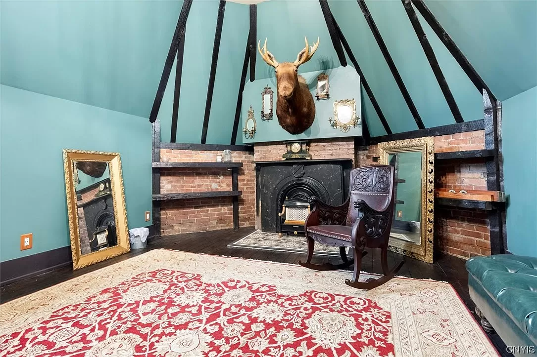 attic level with angled walls and black mantel with exposed brick