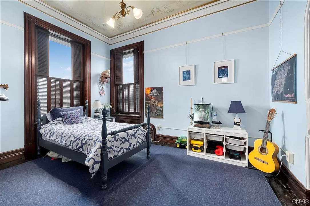 bedroom with two exposures and painted design on ceiling