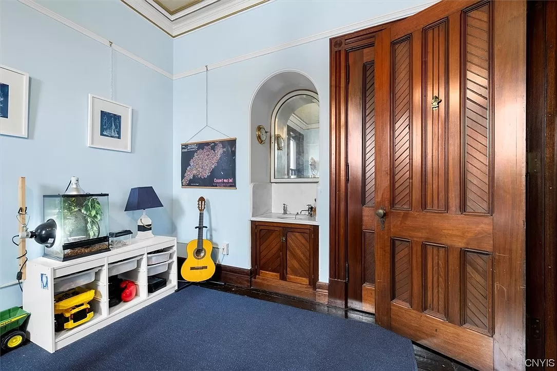 bedroom with sink in arched nook