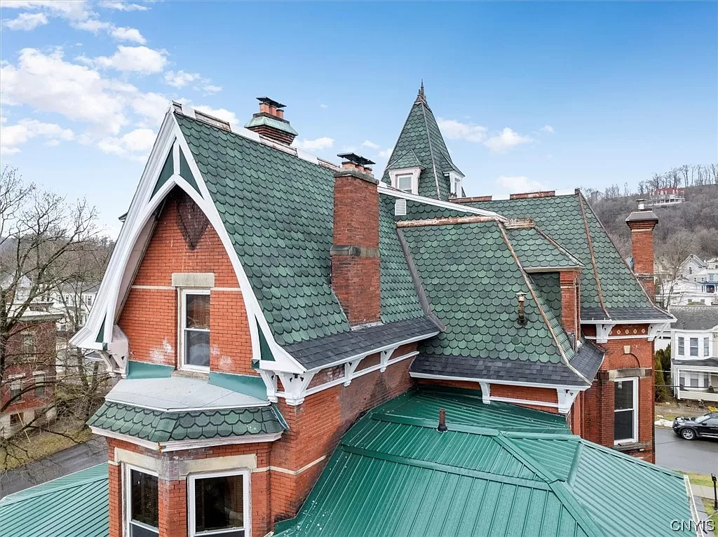 roofline of the house with green shingles and multiple chimneys