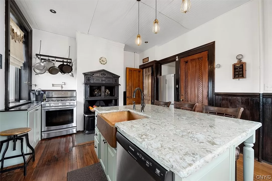 kitchen with central island, green cabinets and wainscoting