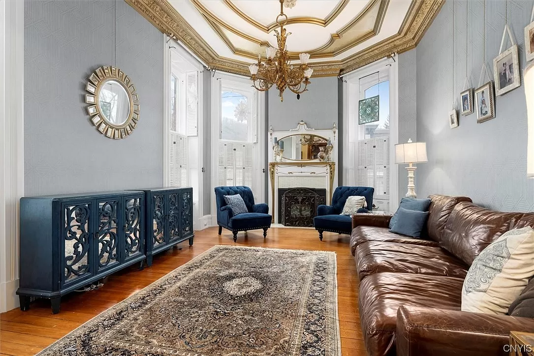 parlor with bay window and white and gold mantel