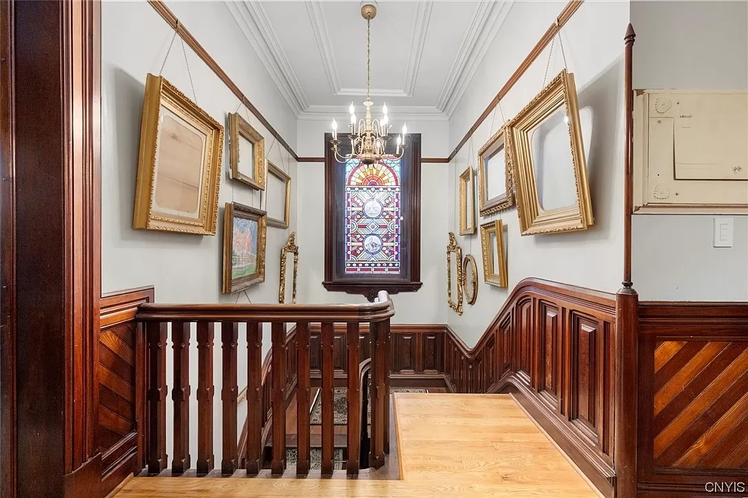 staircase with chandelier and picture rail