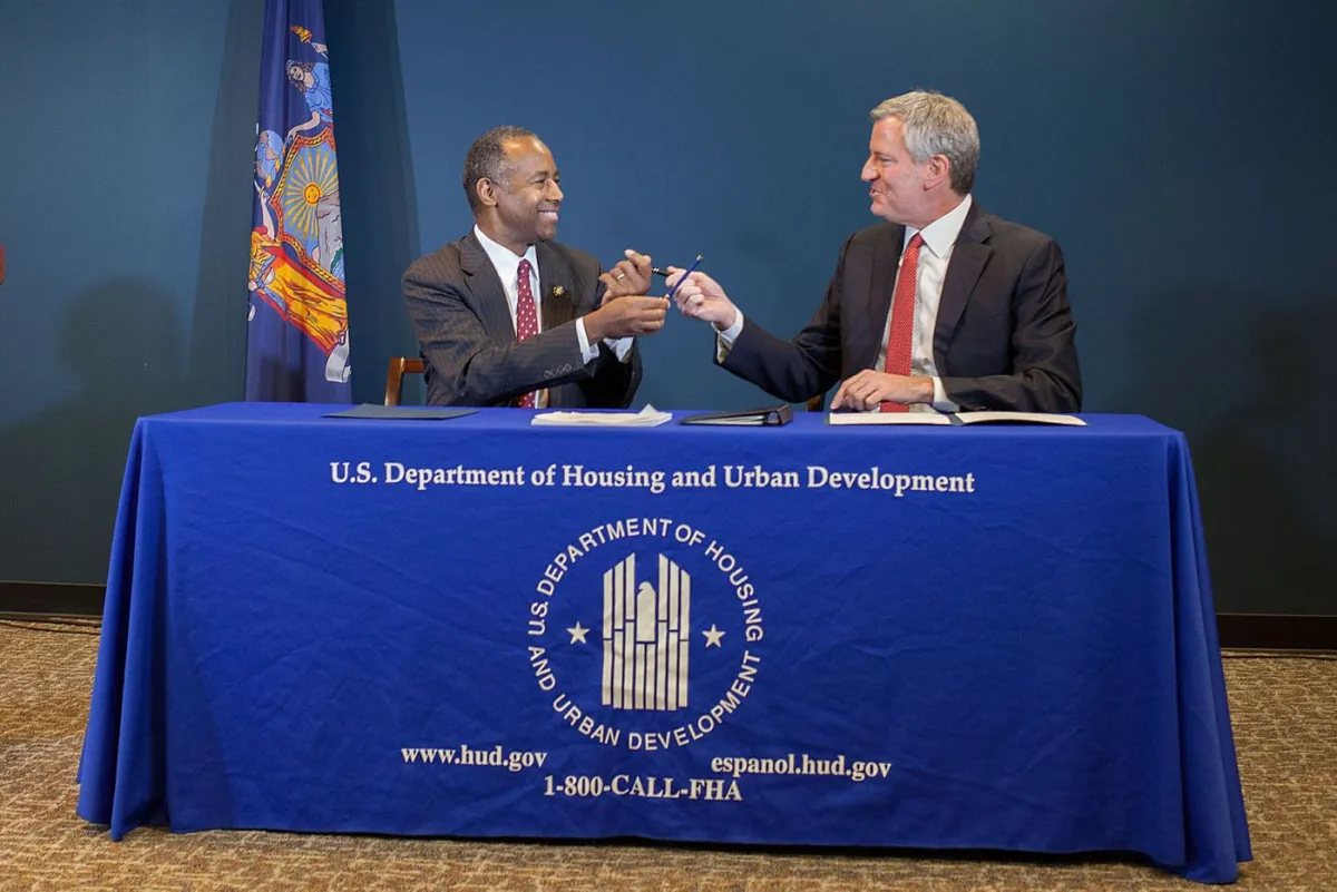 nycha - ben carson and bill de blasio sitting at a table