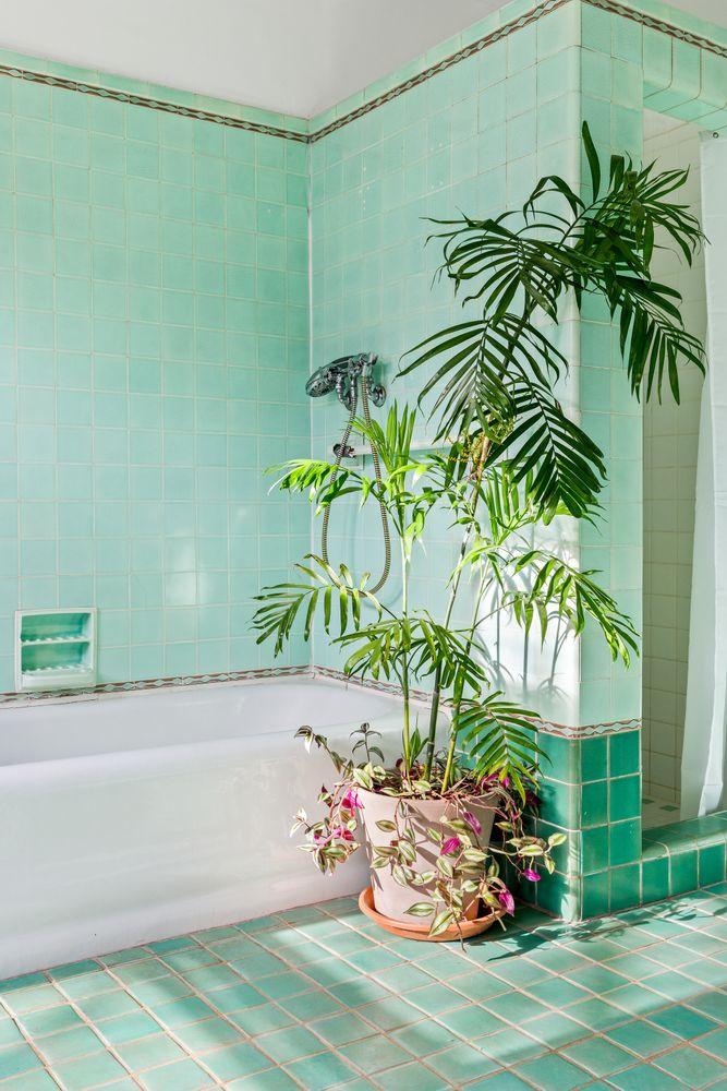 bathroom with white tub and walls and floors of jade green tile