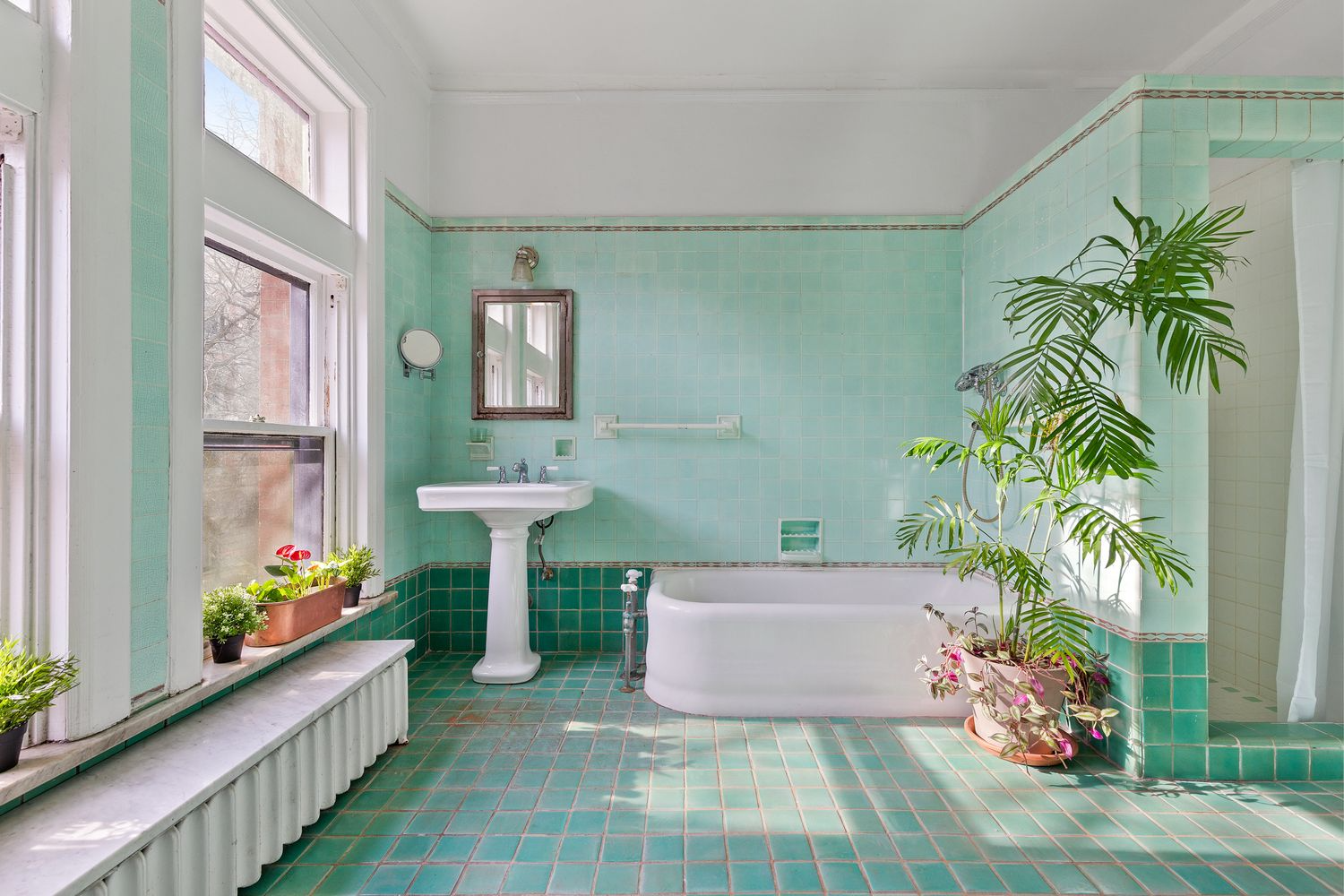 large bathroom with white fixtures and walls and floor of jade green tile