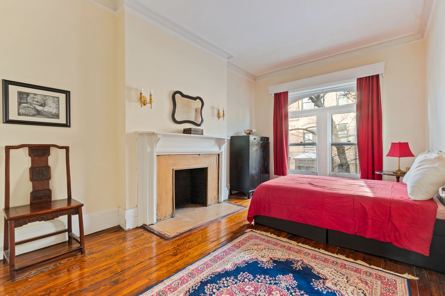 bedroom with original wood floors and a white painted mantel