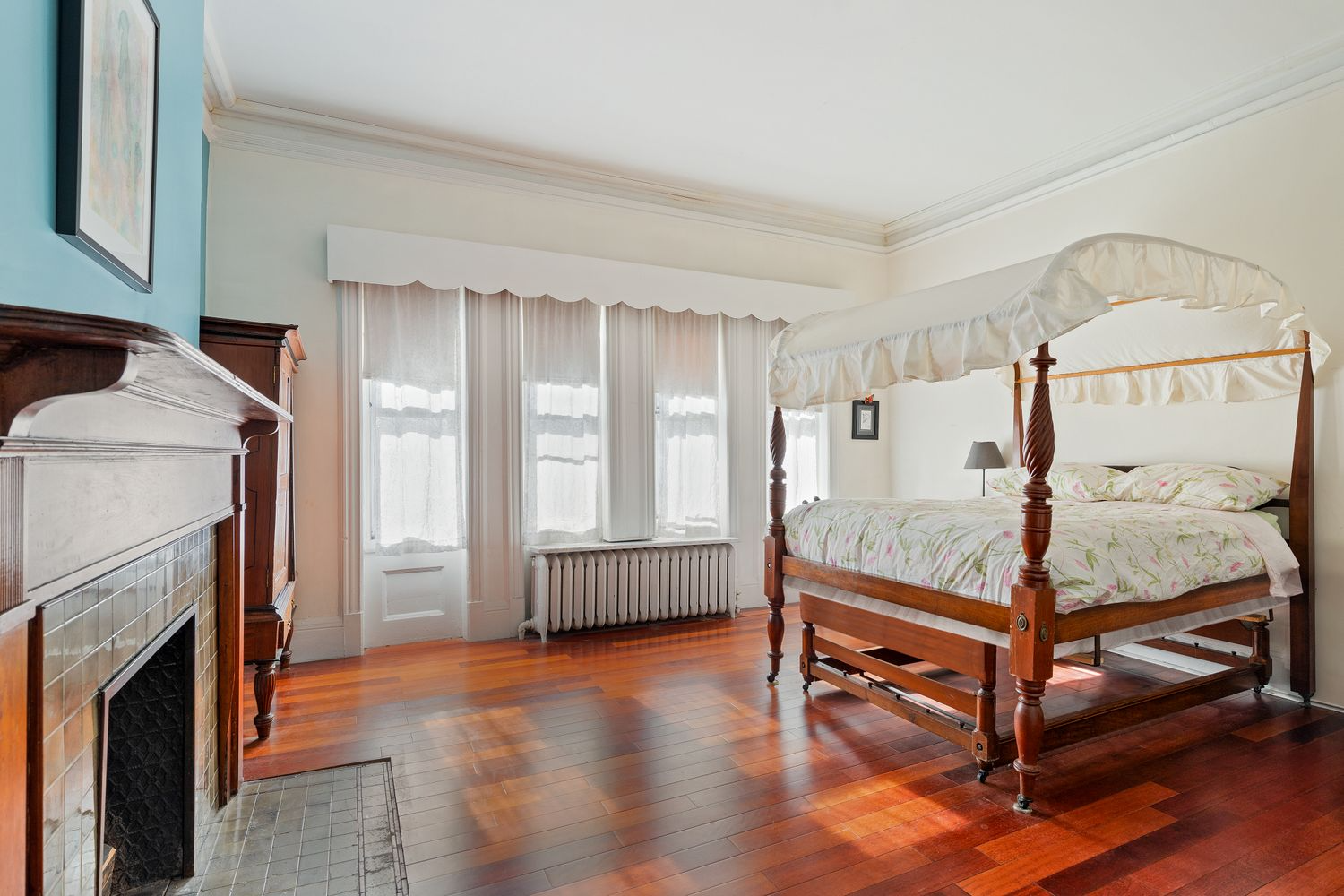 bedroom with wood mantel and bay window