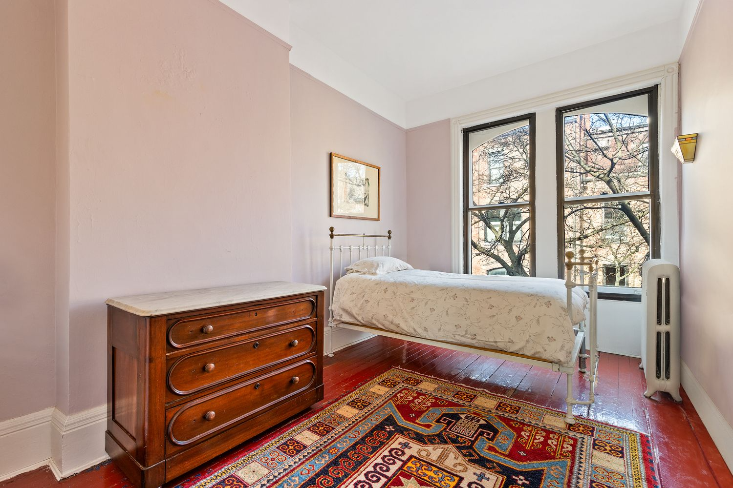 bedroom with pink walls and two windows