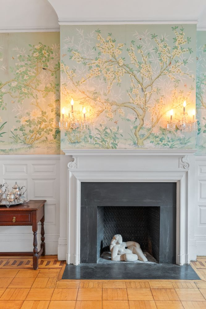 detail of dining room mantel with tree wallpaper above