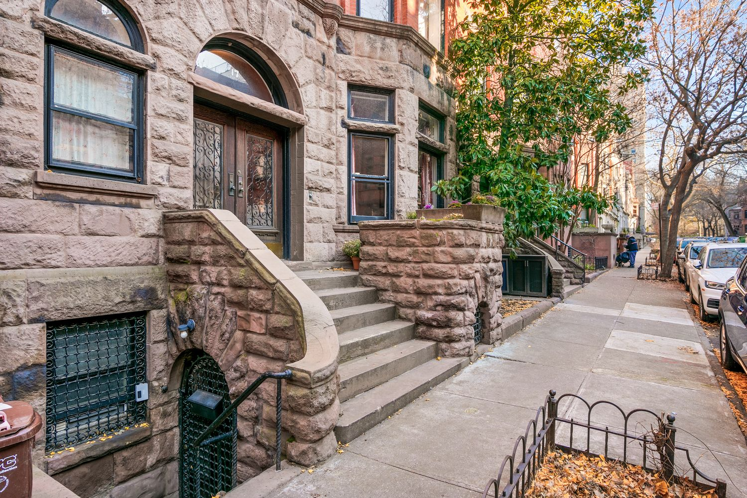 base of house with rough faced brownstone and a stoop