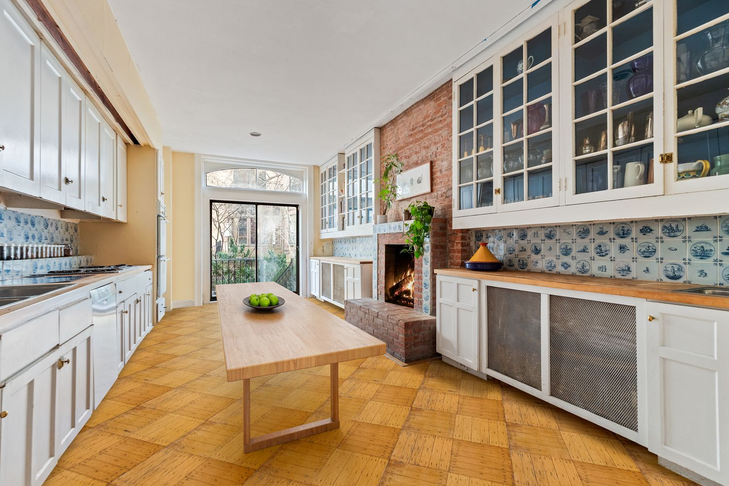 kitchen with delft tile backsplash and sliding doors to rear yard - virtually staged with a center table