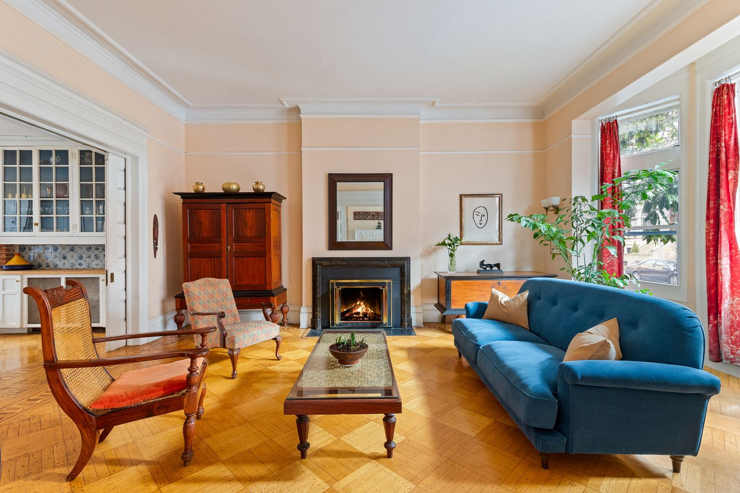 parlor with working fireplace and pocket doors to kitchen