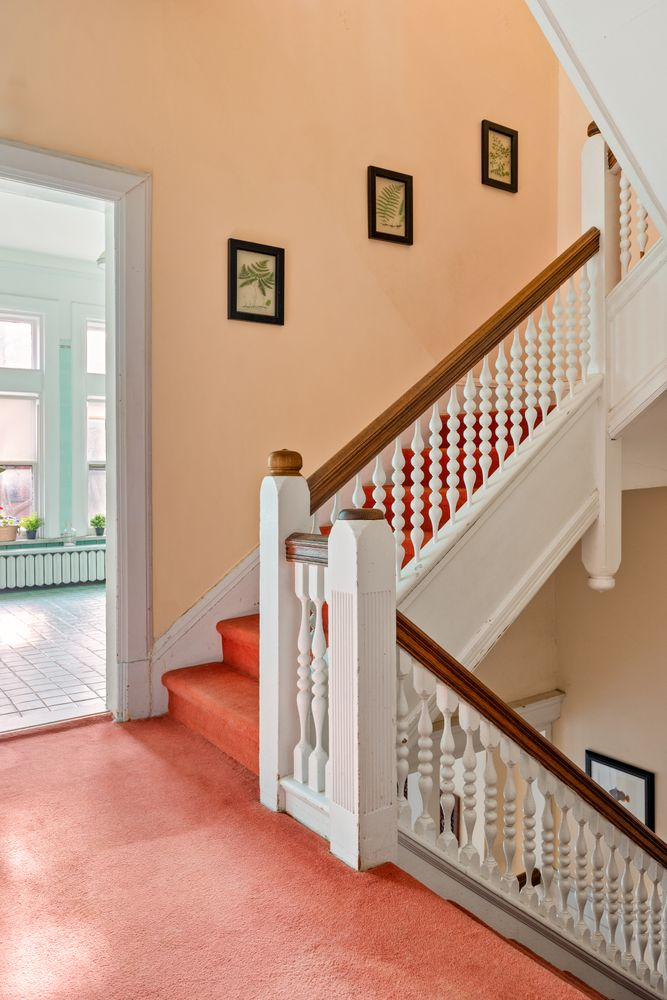 stair and hall with coral colored carpet