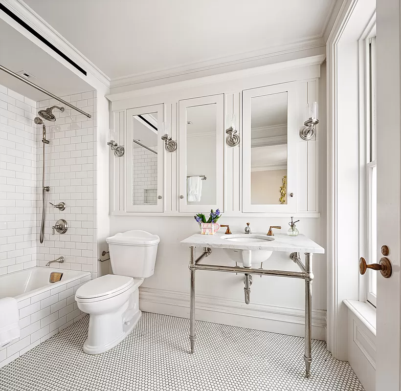 bathroom with white fixtures and white subway tile around the bathtub