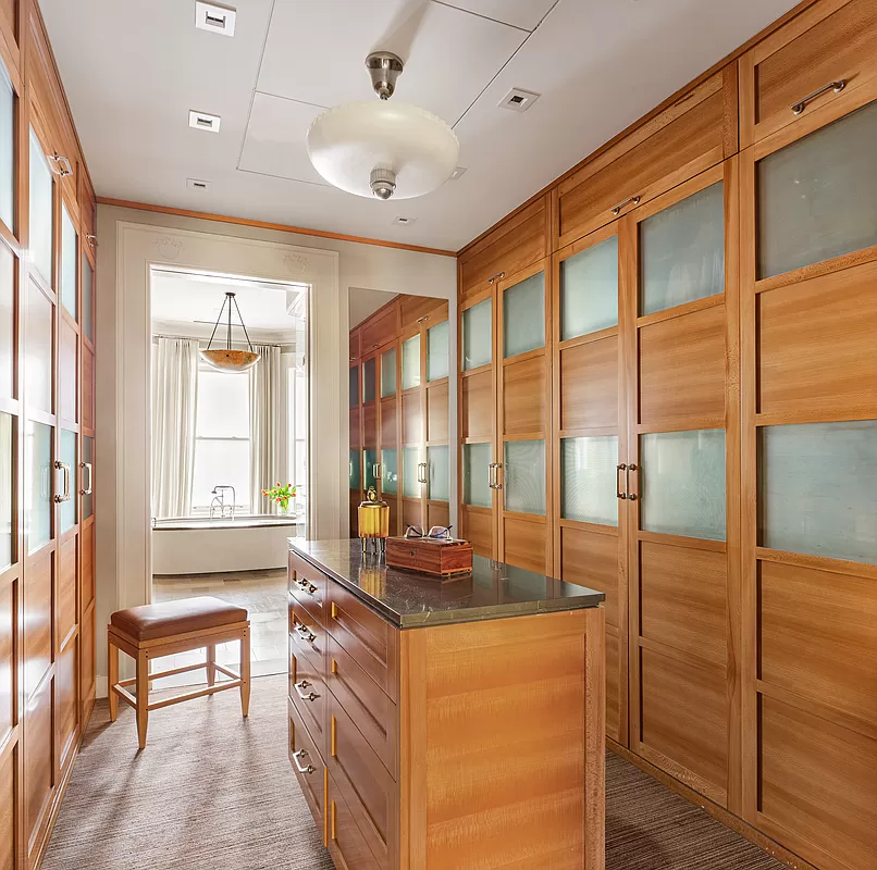 dressing room with built-in closets and an island