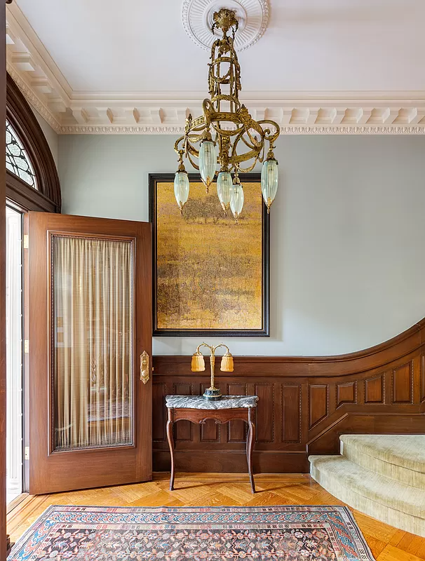 entry with wainscoting and a ceiling medallion